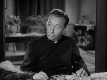 Movie still from “Going My Way” (1944), directed by Leo McCarey – A man sitting at a table with a knife in his hand; Close Up shot, High angle