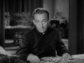 Movie still from “Going My Way” (1944), directed by Leo McCarey – A man sitting at a table with a plate of food in front of him; Close Up shot, High angle