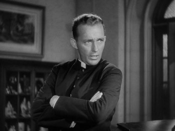 Movie still from “Going My Way” (1944), directed by Leo McCarey – A black and white photo of a man with his arms crossed; Close Up shot, Low angle