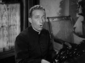 Movie still from “Going My Way” (1944), directed by Leo McCarey – A man wearing a priest's outfit sitting in a chair; Close Up shot, High angle