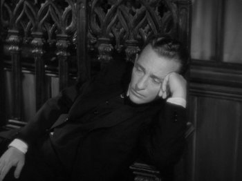 Movie still from “Going My Way” (1944), directed by Leo McCarey – A black and white photo of a man sitting in a chair; Medium shot, High angle