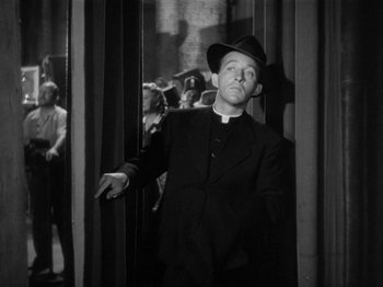 Movie still from “Going My Way” (1944), directed by Leo McCarey – A man wearing a priest's outfit and a hat; Medium shot, Low angle