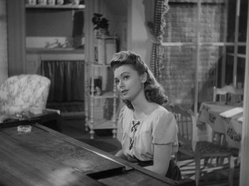 Movie still from “Going My Way” (1944), directed by Leo McCarey – A woman sitting at a table in a room; Medium shot, High angle