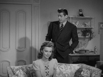 Movie still from “Going My Way” (1944), directed by Leo McCarey – A man and a woman sitting on top of a couch; Medium shot, Over the shoulder angle