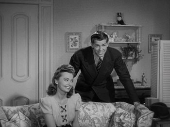Movie still from “Going My Way” (1944), directed by Leo McCarey – A man and a woman are sitting on a couch; Medium shot, High angle