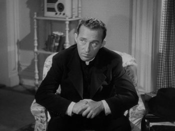 Movie still from “Going My Way” (1944), directed by Leo McCarey – A man sitting in a chair in a room; Medium shot, High angle