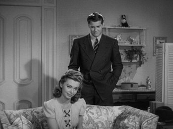 Movie still from “Going My Way” (1944), directed by Leo McCarey – A man and a woman sitting on top of a couch; Medium shot, High angle