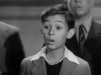 Movie still from “Going My Way” (1944), directed by Leo McCarey – A young boy in a suit and tie looking surprised; Close Up shot, High angle
