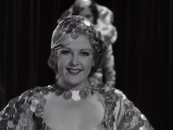 Movie still from “Gold Diggers of 1933” (1933), directed by Mervyn LeRoy – A black and white photo of a woman in a costume; Close Up shot, Low angle