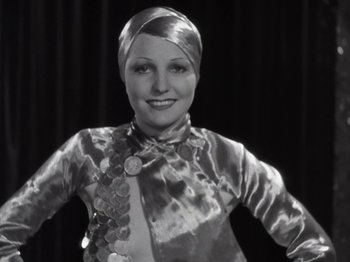 Movie still from “Gold Diggers of 1933” (1933), directed by Mervyn LeRoy – A black and white photo of a woman wearing a turban; Close Up shot, Low angle