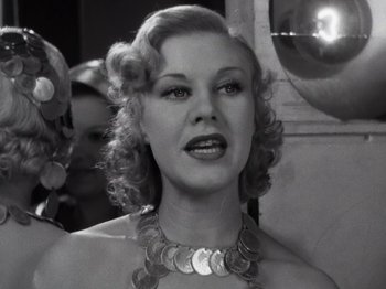 Movie still from “Gold Diggers of 1933” (1933), directed by Mervyn LeRoy – A black and white photo of a woman with a coin necklace around her neck; Close Up shot, Low angle
