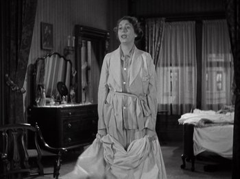 Movie still from “Gold Diggers of 1933” (1933), directed by Mervyn LeRoy – An old photo of an old woman in a room; Medium shot, Low angle
