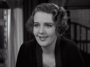 Movie still from “Gold Diggers of 1933” (1933), directed by Mervyn LeRoy – An old photo of a woman smiling for the camera; Close Up shot, High angle