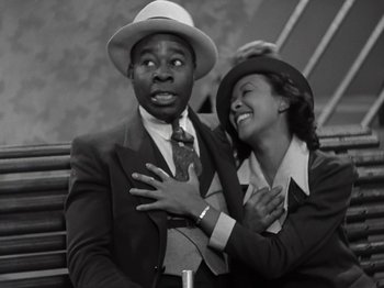 Movie still from “Gold Diggers of 1933” (1933), directed by Mervyn LeRoy – A man and a woman sitting next to each other on a park bench; Medium shot, High angle