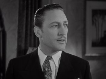 Movie still from “Gold Diggers of 1933” (1933), directed by Mervyn LeRoy – A man wearing a suit and tie in front of a window; Close Up shot, Low angle