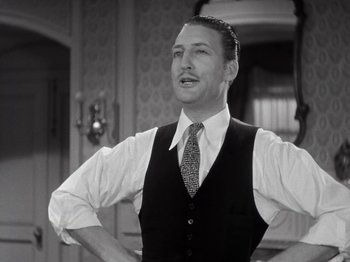 Movie still from “Gold Diggers of 1933” (1933), directed by Mervyn LeRoy – A black and white photo of a man wearing a vest and tie; Medium shot, Low angle