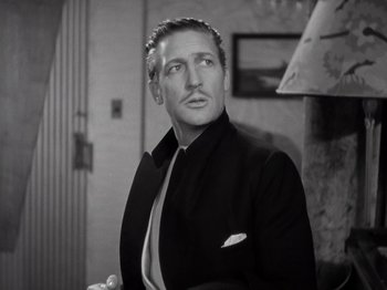 Movie still from “Gold Diggers of 1933” (1933), directed by Mervyn LeRoy – A black and white photo of a man in a suit and tie; Close Up shot, Low angle