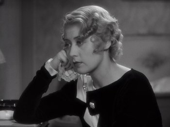 Movie still from “Gold Diggers of 1933” (1933), directed by Mervyn LeRoy – An old photo of a woman sitting at a table; Close Up shot, High angle