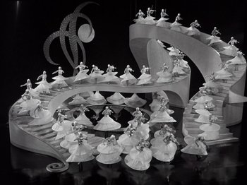 Movie still from “Gold Diggers of 1933” (1933), directed by Mervyn LeRoy – A group of people standing on top of a spiral staircase; Extreme Wide shot, High angle
