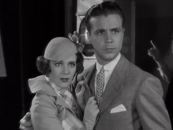 Movie still from “Gold Diggers of 1933” (1933), directed by Mervyn LeRoy – A man and a woman posing for a picture; Close Up shot, Low angle