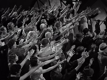 Movie still from “Gold Diggers of 1933” (1933), directed by Mervyn LeRoy – A group of people raising their hands in a crowd; Extreme Wide shot, High angle