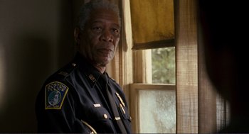 Movie still from “Gone Baby Gone” (2007), directed by Ben Affleck – A man in a police uniform standing in front of a window; Close Up shot, Over the shoulder angle