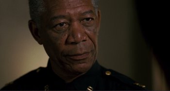 Movie still from “Gone Baby Gone” (2007), directed by Ben Affleck – An older man wearing a black uniform looking at the camera; Close Up shot, Low angle