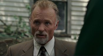 Movie still from “Gone Baby Gone” (2007), directed by Ben Affleck – An older man in a suit and tie looking to his left; Close Up shot, Over the shoulder angle