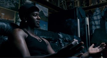 Movie still from “Gone Baby Gone” (2007), directed by Ben Affleck – A man sitting on a couch in a living room; Close Up shot, Low angle