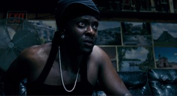 Movie still from “Gone Baby Gone” (2007), directed by Ben Affleck – A man in a black shirt and a black hat; Close Up shot, Low angle