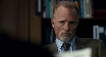 Movie still from “Gone Baby Gone” (2007), directed by Ben Affleck – An older man in a suit and tie looking at the camera; Close Up shot, Over the shoulder angle