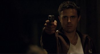 Movie still from “Gone Baby Gone” (2007), directed by Ben Affleck – A man is holding a gun in his hand; Close Up shot, Low angle