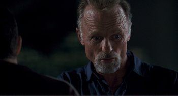 Movie still from “Gone Baby Gone” (2007), directed by Ben Affleck – An older man with a gray beard looking at the camera; Close Up shot, Over the shoulder angle