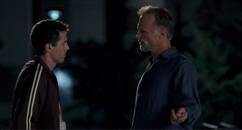 Movie still from “Gone Baby Gone” (2007), directed by Ben Affleck – Two men talking to each other in the dark; Medium shot, Over the shoulder angle