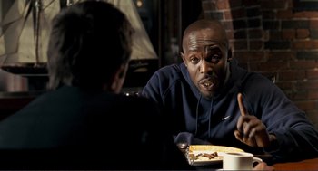 Movie still from “Gone Baby Gone” (2007), directed by Ben Affleck – A man sitting in front of a plate of food; Close Up shot, Over the shoulder angle