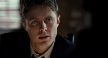 Movie still from “Gone Baby Gone” (2007), directed by Ben Affleck – A person wearing a suit and tie; Close Up shot, Over the shoulder angle