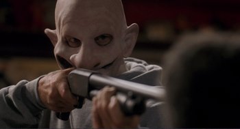 Movie still from “Gone Baby Gone” (2007), directed by Ben Affleck – A man holding a gun while wearing a mask; Close Up shot, Over the shoulder angle