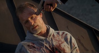 Movie still from “Gone Baby Gone” (2007), directed by Ben Affleck – A man is getting his hair cut by a man with a gun; Close Up shot, High angle