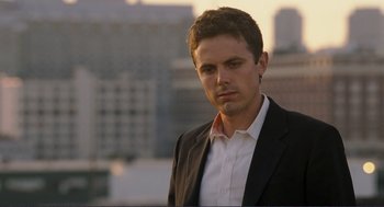 Movie still from “Gone Baby Gone” (2007), directed by Ben Affleck – A man wearing a suit and tie standing outside; Close Up shot, Low angle