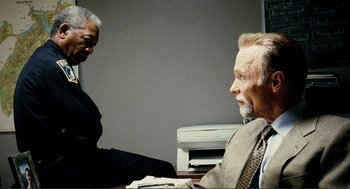 Movie still from “Gone Baby Gone” (2007), directed by Ben Affleck – Two older men sitting at a table talking to each other; Medium shot, Over the shoulder angle