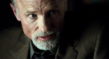 Movie still from “Gone Baby Gone” (2007), directed by Ben Affleck – An older man with a beard and a suit and tie; Close Up shot, Over the shoulder angle