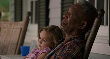 Movie still from “Gone Baby Gone” (2007), directed by Ben Affleck – An older man holding a little girl while sitting on a chair; Close Up shot, Over the shoulder angle