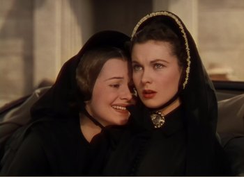 Movie still from “Gone with the Wind” (1939), directed by George Cukor – Two women in black clothes are posing for a picture; Close Up shot, High angle