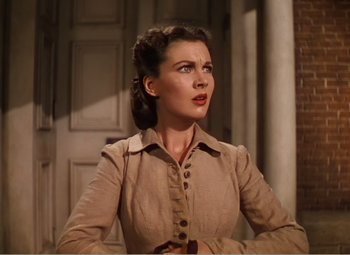 Movie still from “Gone with the Wind” (1939), directed by George Cukor – A woman standing in front of a door looking to the side; Close Up shot, Low angle
