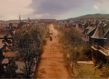 Movie still from “Gone with the Wind” (1939), directed by George Cukor – An aerial view of a dirt road with trees and buildings; Extreme Wide shot, High angle