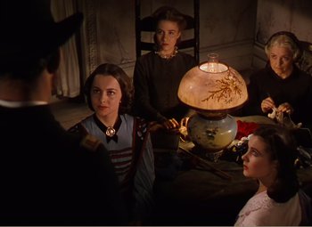 Movie still from “Gone with the Wind” (1939), directed by George Cukor – A group of people gathered around a lamp; Medium shot, High angle
