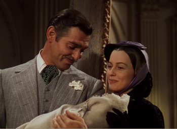 Movie still from “Gone with the Wind” (1939), directed by George Cukor – A man and a woman holding a baby in a room; Medium shot, Low angle