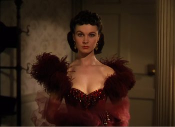 Movie still from “Gone with the Wind” (1939), directed by George Cukor – A woman in a red dress with feathers on her shoulders; Close Up shot, Low angle