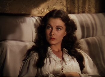 Movie still from “Gone with the Wind” (1939), directed by George Cukor – A beautiful woman sitting on a couch in a room; Close Up shot, High angle