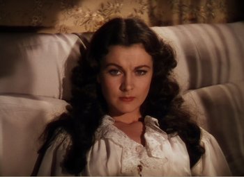 Movie still from “Gone with the Wind” (1939), directed by George Cukor – A woman sitting on top of a couch in front of a window; Close Up shot, High angle